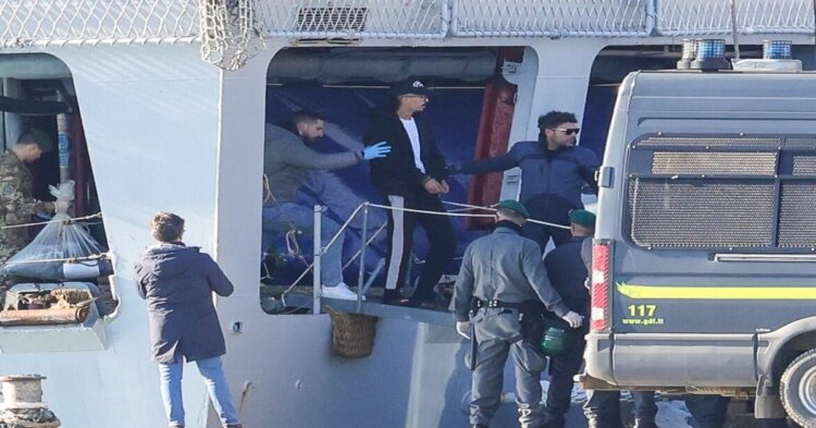 alt="Sbarco di migranti in manette in Albania, su una nave militare"